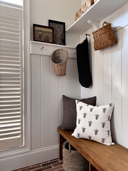 Almond Jumper Pillow Cover styled on wooden bench.