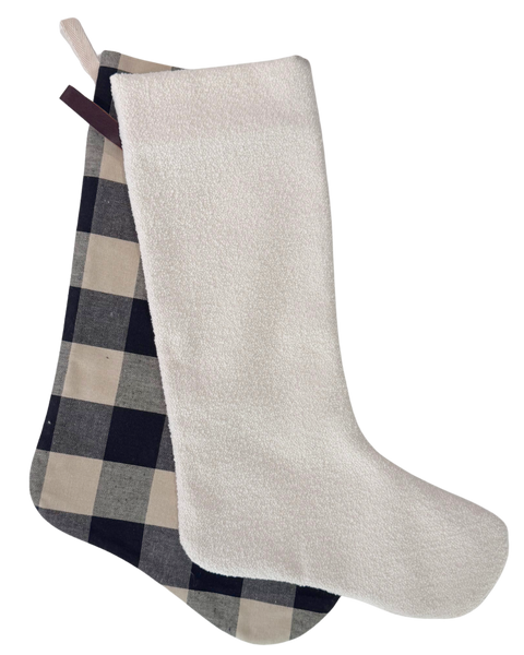A Christmas stocking with a cream-colored plush fleece body and a navy blue, beige, and gray buffalo plaid patterned foot, shown against a plain white background.