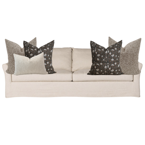 Beige sofa with decorative pillows on a white background