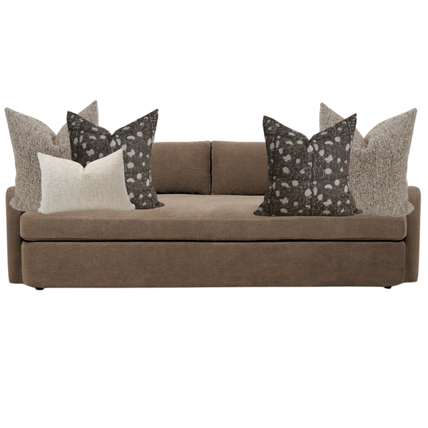 Brown sofa with decorative pillows on a white background