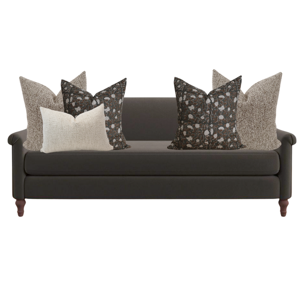 Dark gray sofa with decorative pillows on a white background