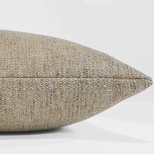 Gold Kissed woven indoor/outdoor pillow cover in warm beige performance fabric for coastal living rooms, patios, bedrooms, and luxury home decor. Side view of throw pillow
