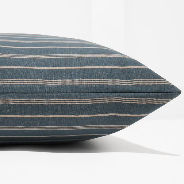 Harbor Pinstripe pillow cover in deep blue indoor upholstery fabric with ivory vertical pinstripes, handmade by Hackner Home for coastal and transitional interiors. Side view of cushion cover. 