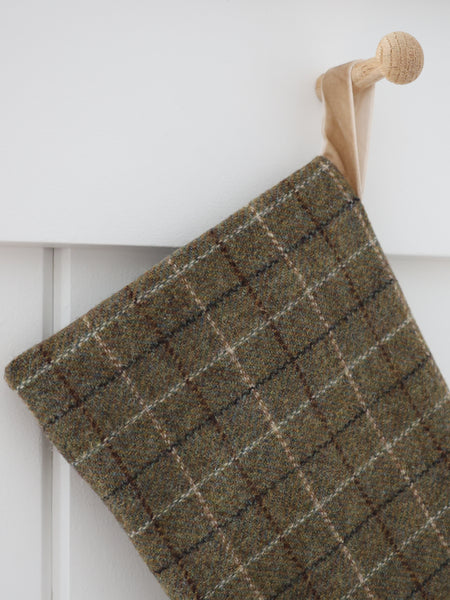 Close-up detail of Deeply Green Plaid Wool Stocking showing soft woven deep green wool, cream and brown plaid lines and a sand velvet hanging loop