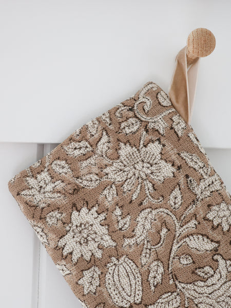Close-up detail of Rose Bud Brown Block Print Stocking showing cream block-printed blooms and seed pods with dark brown outlines on textured camel linen and a sand velvet hook