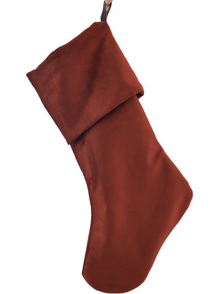 Heritage Design rust-terracotta velvet Christmas stocking with a classic folded cuff and dark brown hanging strap, shown on a white background