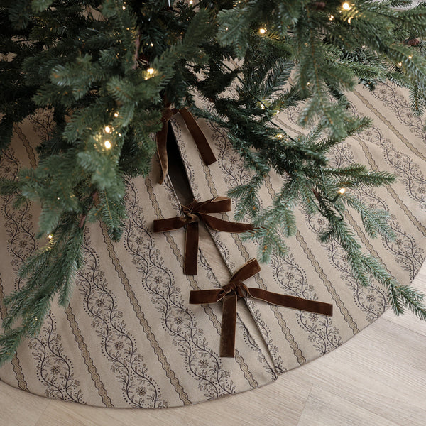Vintage botanical Christmas tree skirt handmade from warm natural designer fabric with brown floral stripes and velvet ribbon ties under a Christmas tree