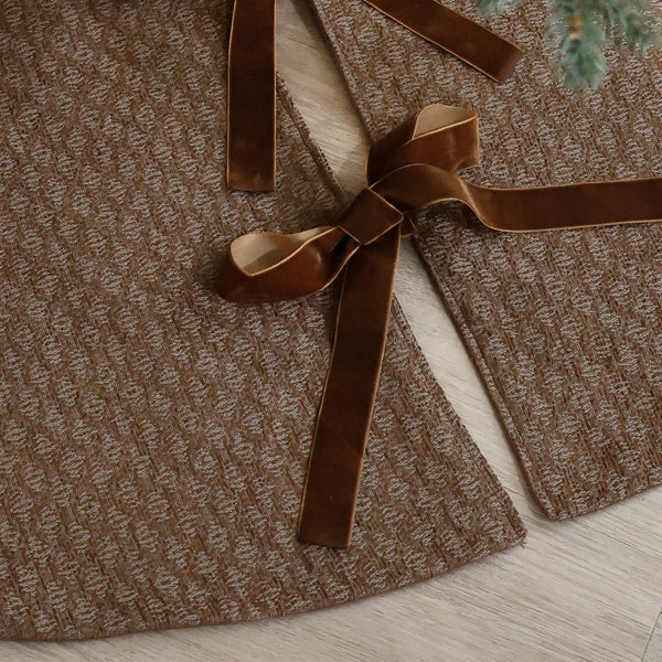 Shop a dark golden handmade Christmas tree skirt crafted in the USA from textured designer fabric with velvet ties. Luxury holiday décor by HACKNER HOME.
