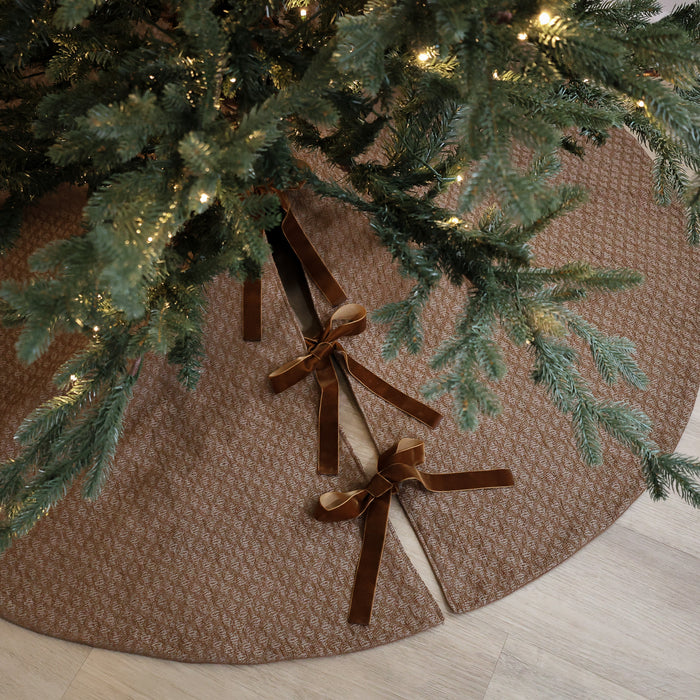 Shop a dark golden handmade Christmas tree skirt crafted in the USA from textured designer fabric with velvet ties. Luxury holiday décor by HACKNER HOME.