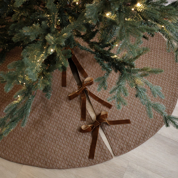 Shop a dark golden handmade Christmas tree skirt crafted in the USA from textured designer fabric with velvet ties. Luxury holiday décor by HACKNER HOME.