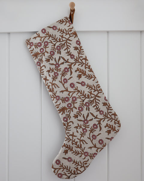 Autumn Vine Linen Block Print Stocking, large natural linen Christmas stocking with hand-printed caramel vines and dusty rose flowers, hanging from a wooden peg on a white paneled wall