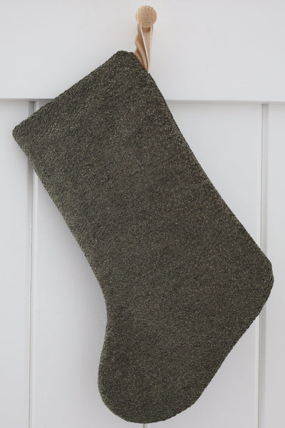 Plush Dark Olive Green Stocking, Boho Design Christmas stocking in soft textured dark olive green with taupe flecks and a sand velvet hook, hanging from a wooden peg on a white paneled wall