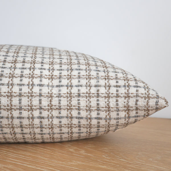 Textured pillow on a wooden surface with a neutral background