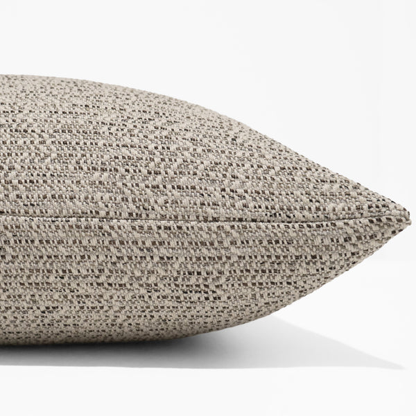 River Pebbles Indoor/Outdoor Pillow Cover in textured woven performance fabric featuring warm ivory, taupe, and charcoal tones, luxury decorative throw pillow cover handmade by Hackner Home for coastal, organic modern, transitional, and outdoor living spaces. Side view of cushion cover.