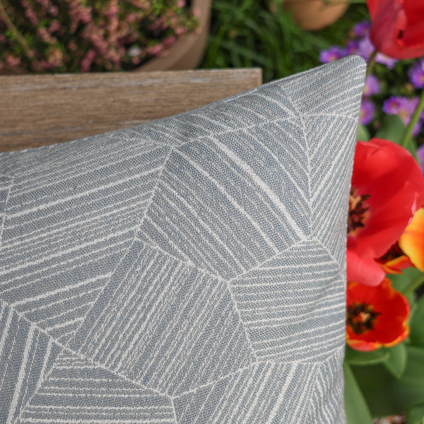 Gray geometric patterned pillow with flowers in the background