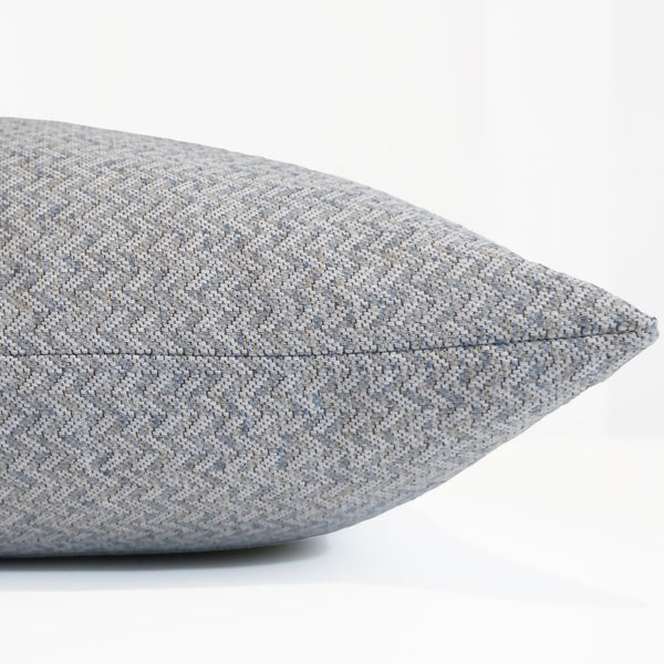 Woven Sea decorative pillow cover handcrafted from a premium cotton and polyester upholstery fabric featuring a soft woven herringbone texture in misty blue and ivory, luxury accent pillow for coastal, transitional, Scandinavian, and modern interiors. Side view of cushion cover. 