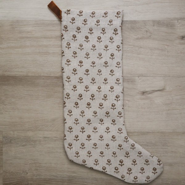 Large linen Christmas stocking with a minimalist brown floral block print pattern and a brown velvet hanging loop, displayed on a plain background.