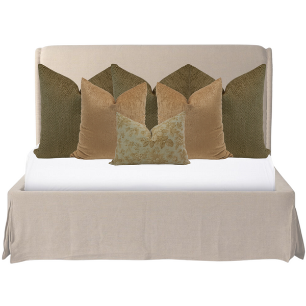 Elegant neutral bed styling featuring olive green and golden velvet throw pillows in layered arrangement on a light beige upholstered bed by Hackner Home.