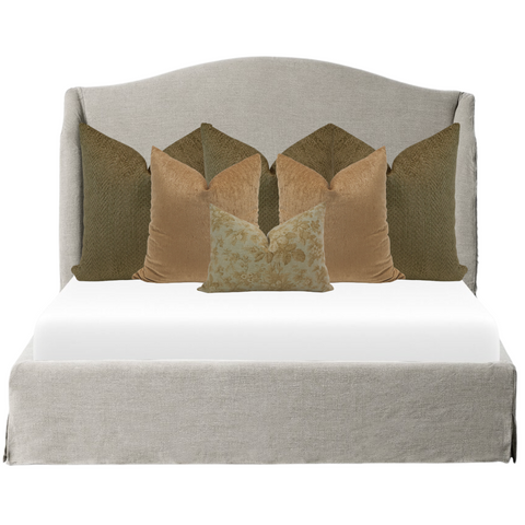 Elegant neutral bed styling featuring olive green and golden velvet throw pillows in layered arrangement on a light beige upholstered bed by Hackner Home.