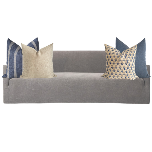 Neutral beige sofa styled with a cohesive mix of blue and cream Hackner Home pillow covers, featuring a balance of solid textures, stripes, and floral block prints for a timeless, coastal-inspired look.