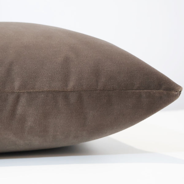 Side view of a mocha brown velvet pillow showcasing its smooth texture, soft sheen, and neatly sewn seams.