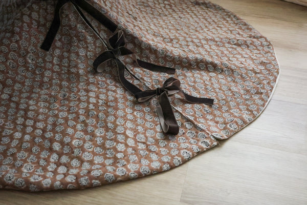 Brick rose block print tree skirt by Hackner Home – handcrafted fabric with velvet ribbon ties in a floral motif.