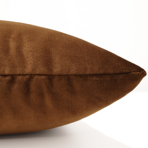 Close-up side view of a copper velvet pillow cover showing its smooth, plush texture and rich sheen.