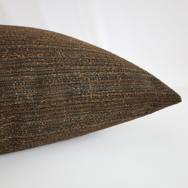 Close-up side view of Hackner Home Cottage Harvest pillow cover showcasing rich brown woven texture with subtle gold and charcoal threads for cozy autumn decor.