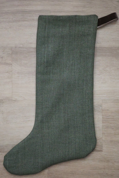 Forest green linen Christmas stocking with a brown velvet hanging loop — elegant and timeless holiday decor by Hackner Home.