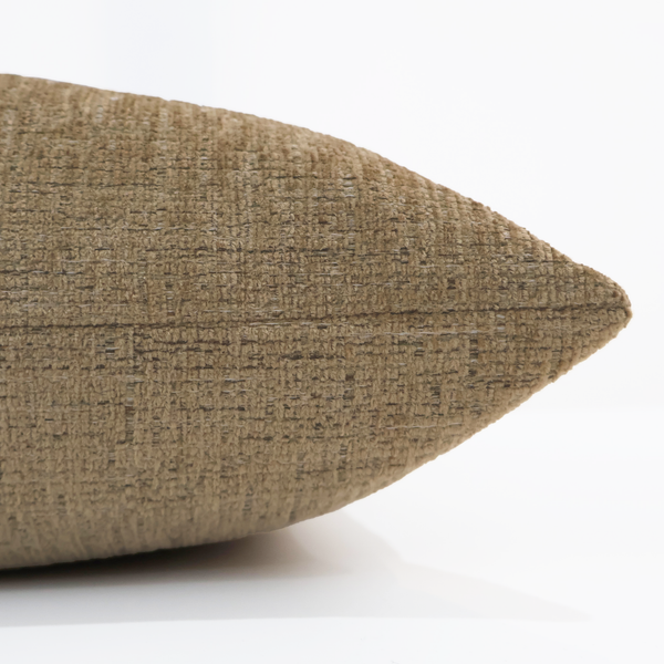 Close-up side view of a golden velvet pillow cover showing its soft, textured weave and warm neutral color.