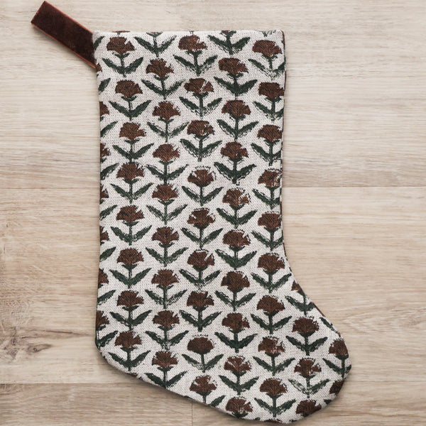 Hackner Home Holly Block Print Boho Christmas Stocking featuring a hand-printed brown and green floral pattern on natural linen with a brown velvet hanging loop.