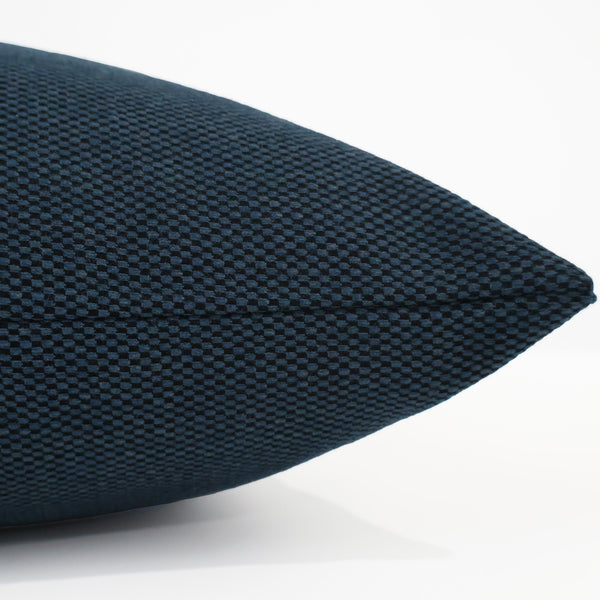 Close-up side view of the Hackner Home Midnight Harbor pillow cover showing its deep navy woven texture and fine seam detail.