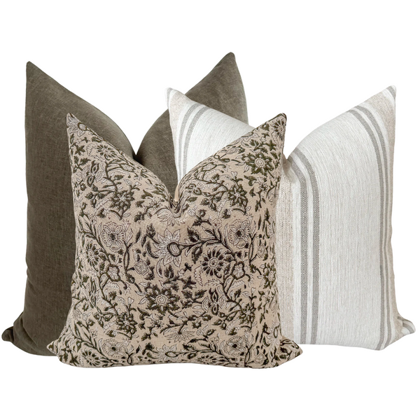 Set of three pillow covers featuring an olive green floral block print pillow, a solid olive pillow, and a white pillow with soft gray stripes.