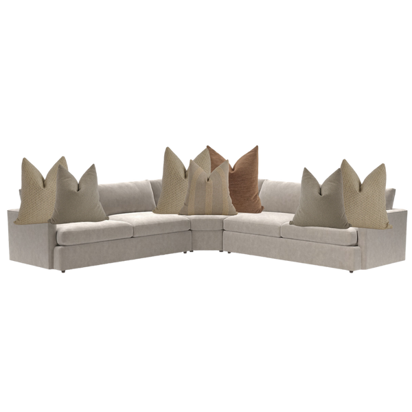 Modern brown sectional sofa styled with neutral throw pillows in beige, taupe, and clay tones — cozy living room corner seating.