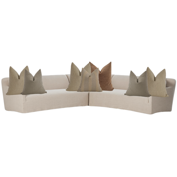 Modern brown sectional sofa styled with neutral throw pillows in beige, taupe, and clay tones — cozy living room corner seating.