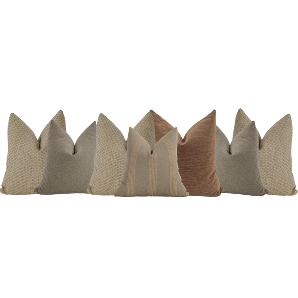 Modern brown sectional sofa styled with neutral throw pillows in beige, taupe, and clay tones — cozy living room corner seating.