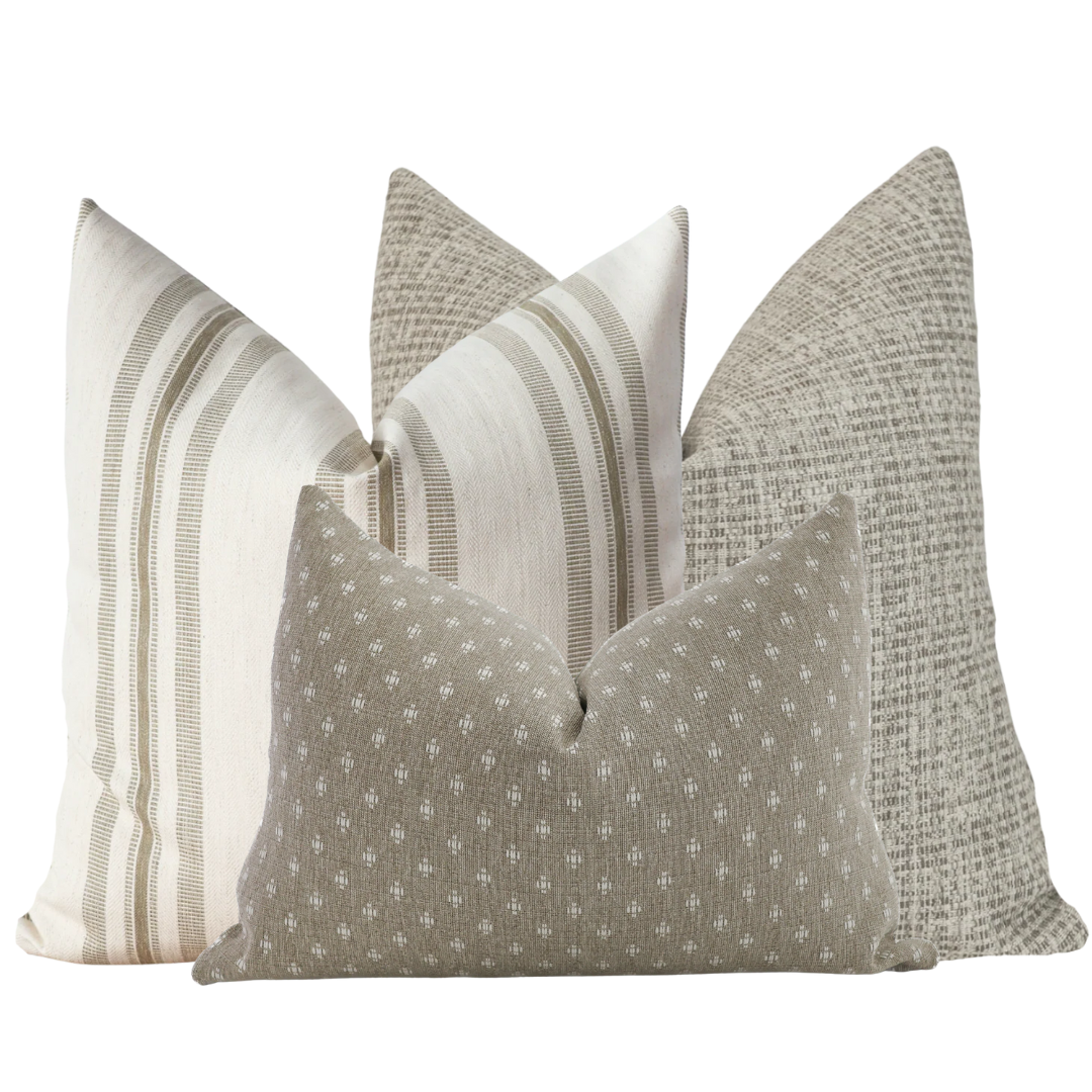 Set of four decorative pillow covers in soft sage and neutral tones, featuring a mix of solid textures, subtle stripes, and small geometric patterns arranged together.
