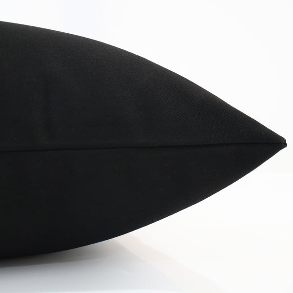Side view of Hackner Home solid black outdoor pillow cover showcasing durable, weather-resistant fabric and sleek stitching detail.