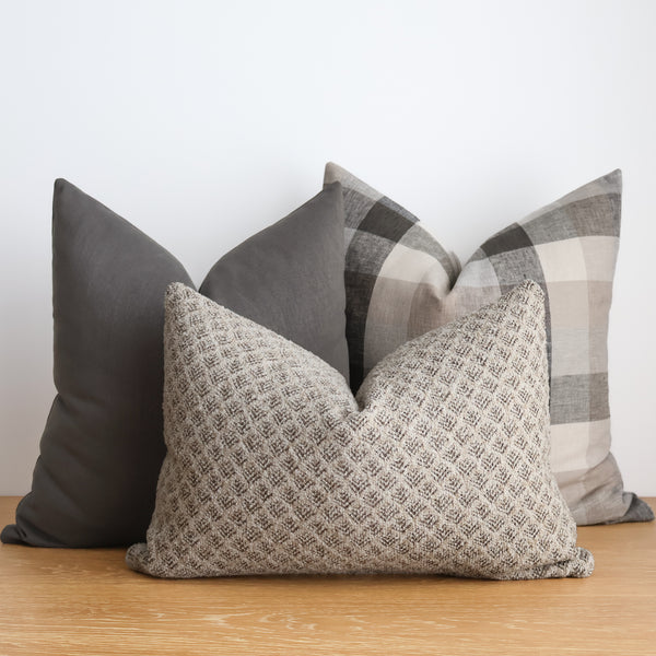 Hackner Home Timberland Pillow Cover Set featuring a mix of earthy neutrals — a textured beige lumbar pillow, a solid gray pillow, and a taupe and gray plaid pillow — creating a cozy, woodland-inspired look.
