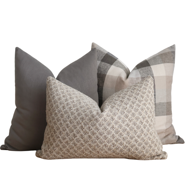 Hackner Home Timberland Pillow Cover Set featuring a mix of earthy neutrals — a textured beige lumbar pillow, a solid gray pillow, and a taupe and gray plaid pillow — creating a cozy, woodland-inspired look.