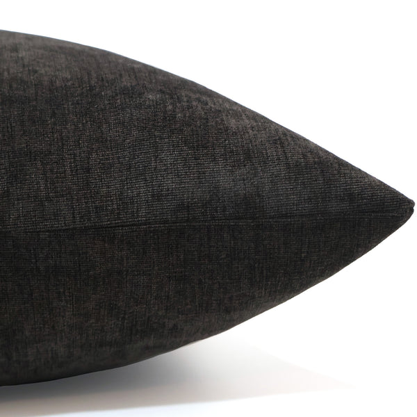 Side view of a dark slate velvet pillow showing its rich texture, fine weave, and neatly sewn seam.