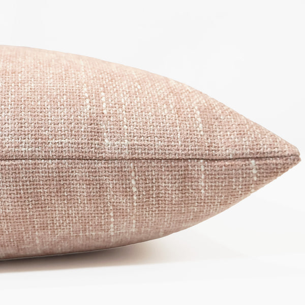 Side view of Hackner Home Woven Petals pillow cover showing blush pink textured weave and soft, modern fabric detail.